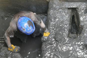 man working in a muddy pit