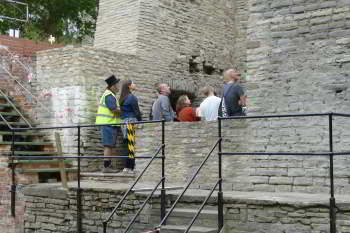 A group of people stand behind a low wall with the rest of the building surrounding them.