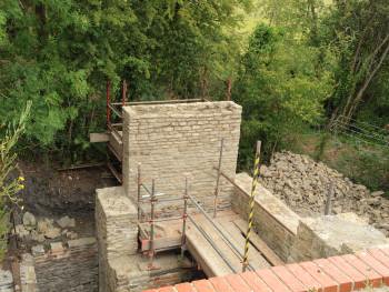 A stone wall with scaffolding behend