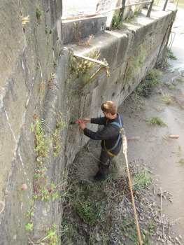 Man working on the edge of a stone wall.